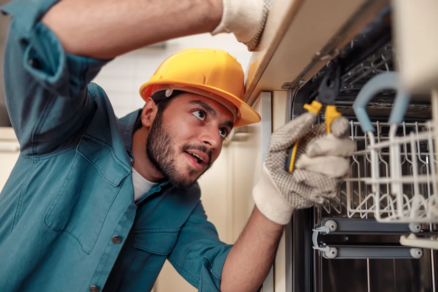 Technician checking a built-in dishwasher for a leak