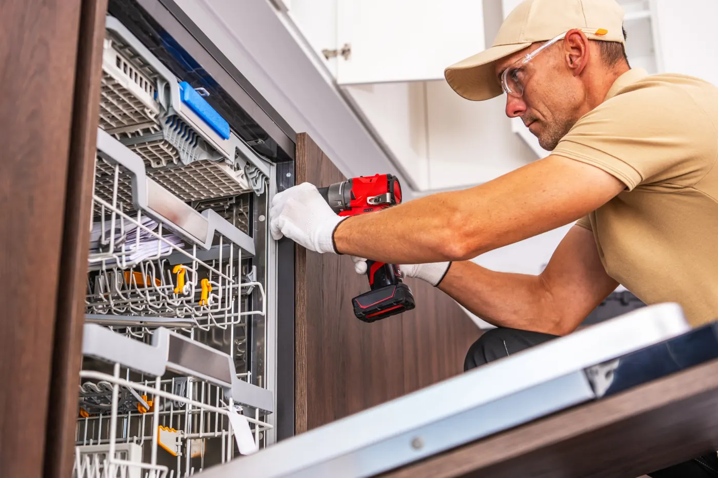 Technician repairing a built-in dishwasher in a Dubai kitchen