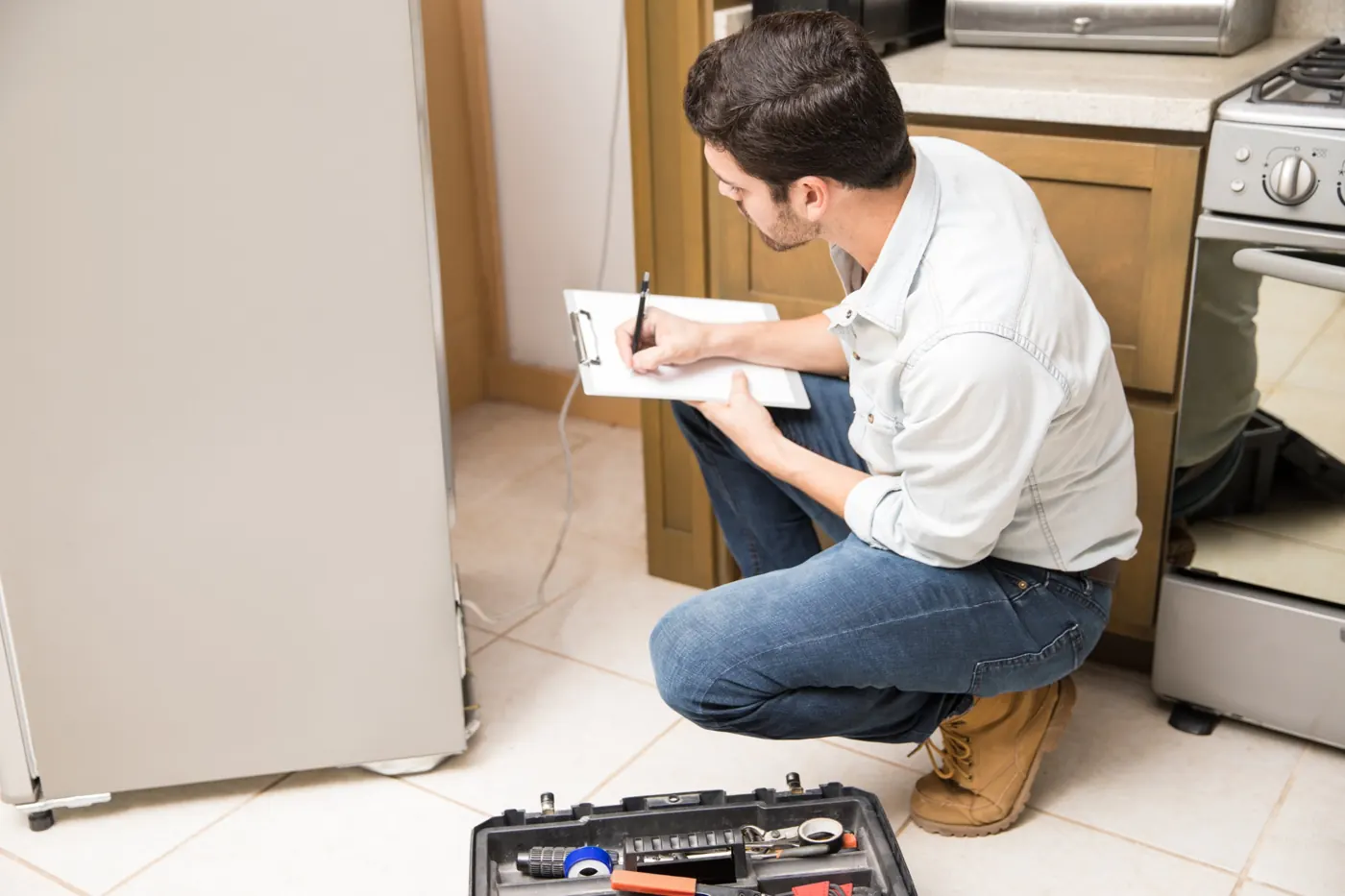 Technician inspecting a fridge that is not cooling