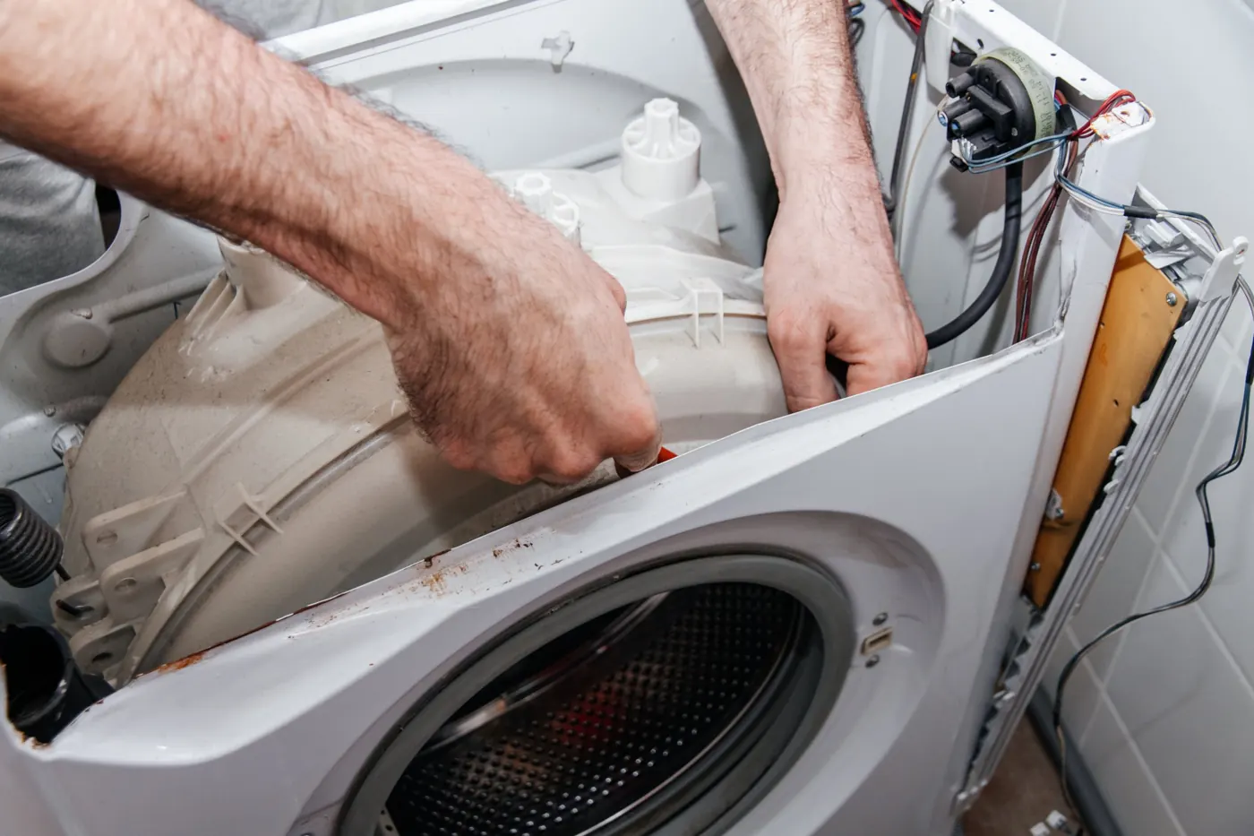 Technician working inside an opened washing machine