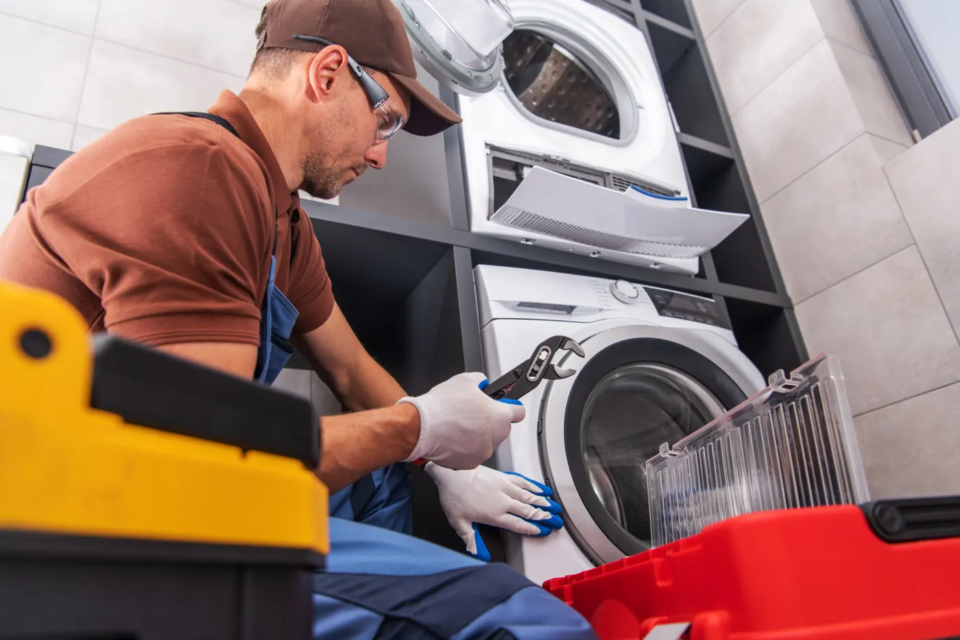 FixQara technician repairing a front load washing machine in Dubai